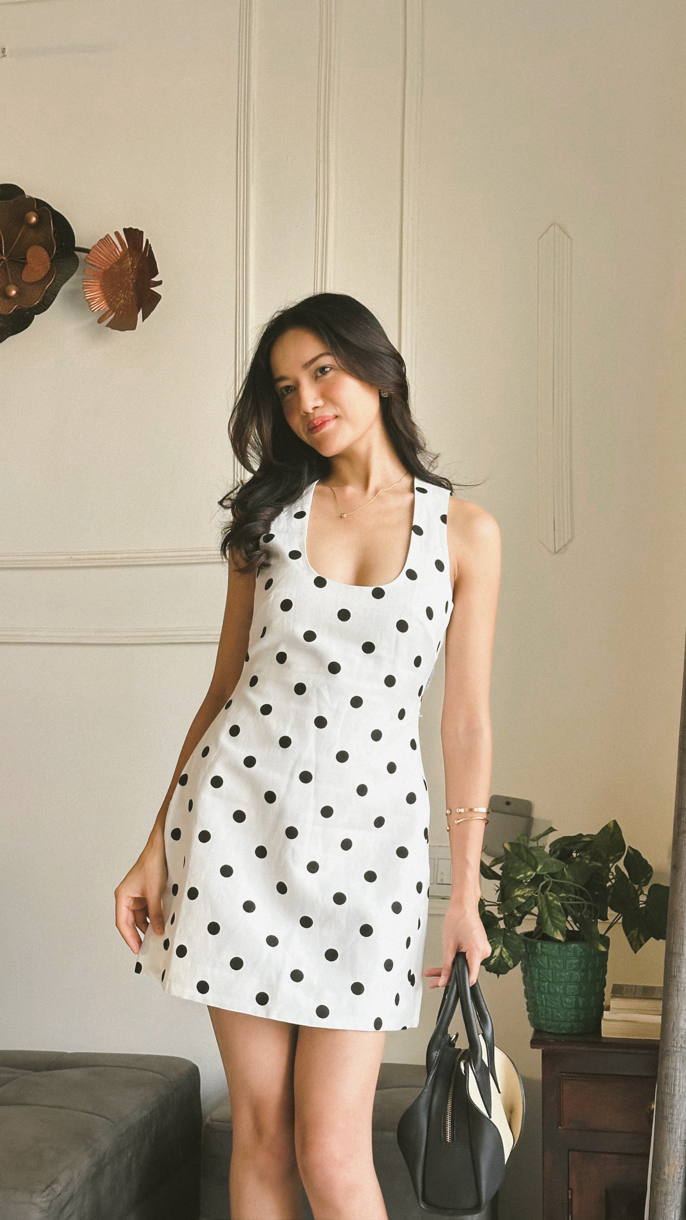 Jelina Derapi in a white polka-dot dress, monochrome studio-style editorial portrait